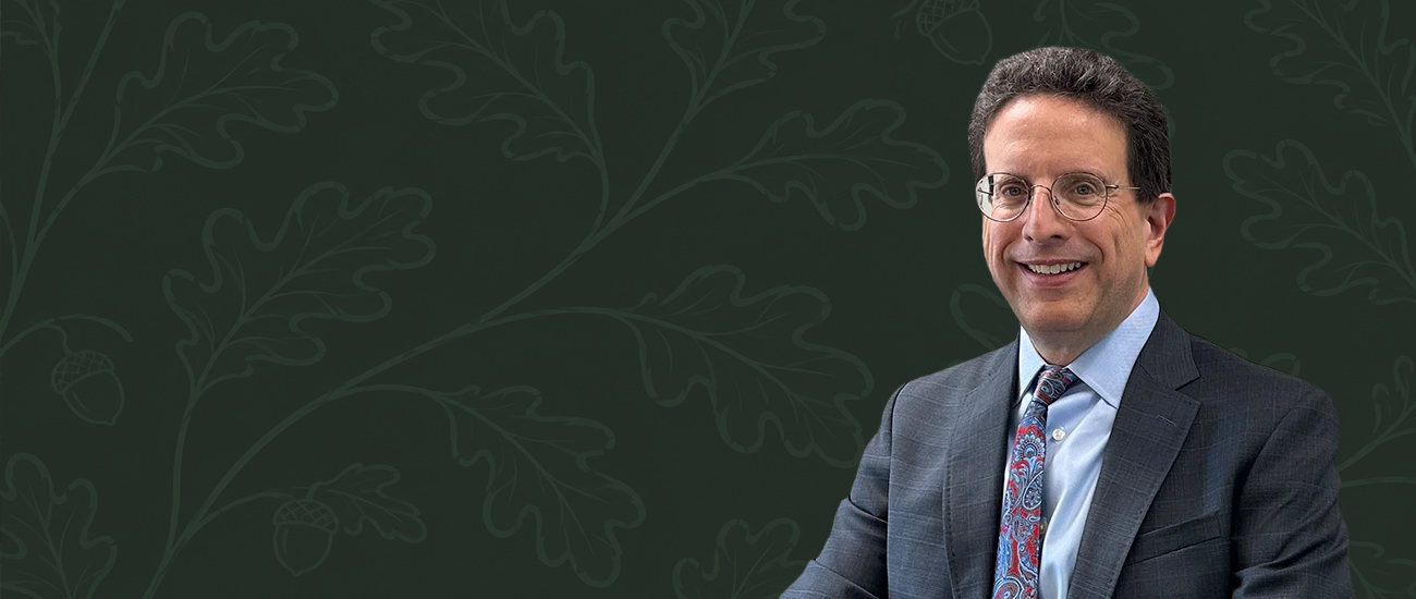 Michael I. Sherman against a dark green background with an oak leaf and acorn pattern.
